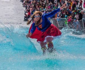 This is an image of a person dressed in a Superman costume skiing in the pond at Mammoth Lakes.