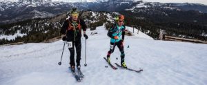 This image is of two skiiers at the top of a snowy mountain.